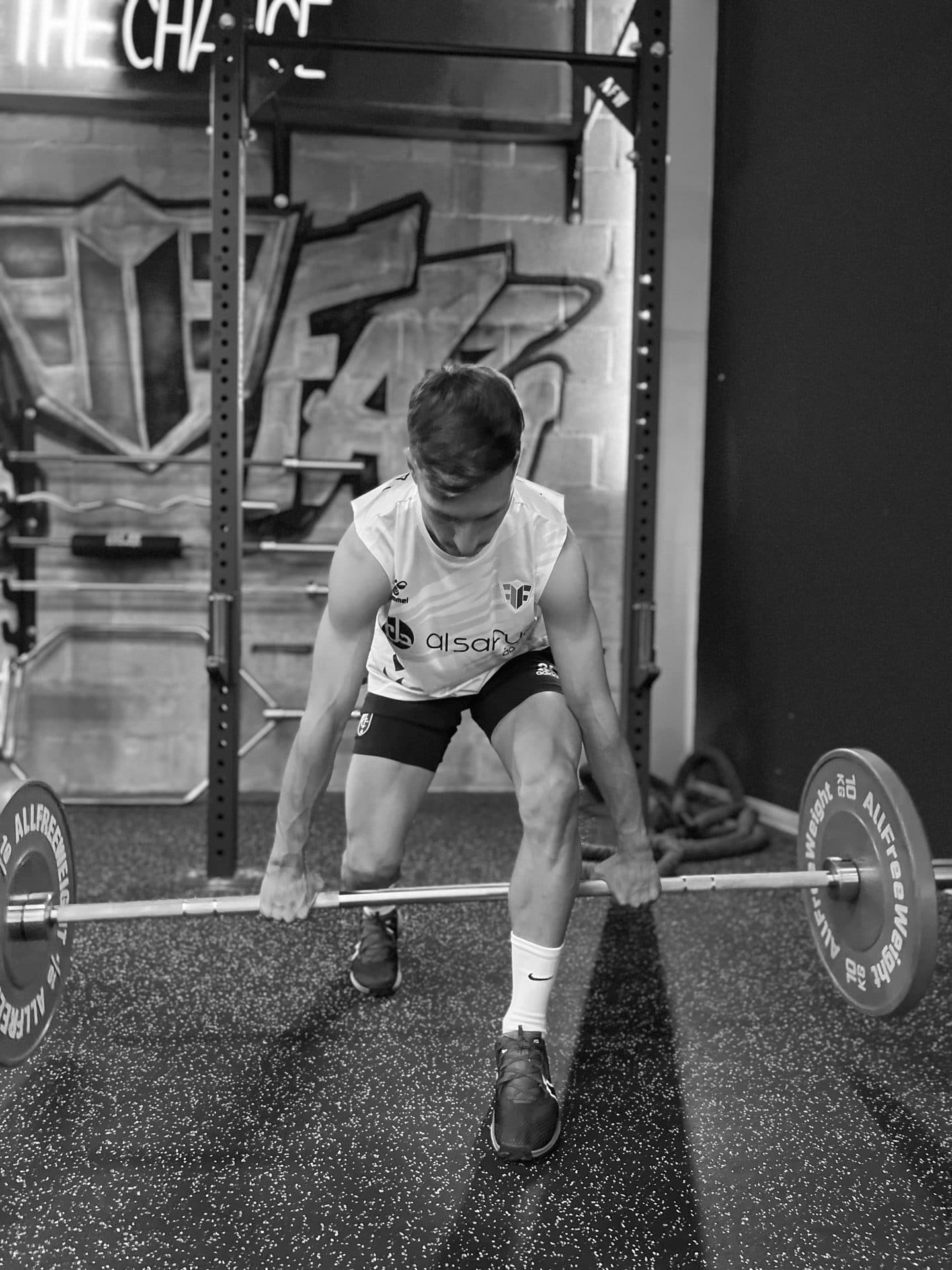 A Footfay player training with a barbell in the strength room at the Málaga centre